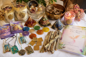 Strumenti per Divinare e Manifestare de La Magia della Fenice: candele rituali, piramidi con intenti, Ogham, rune, carte, portacandele, coppe rituali e manuale introduttivo.